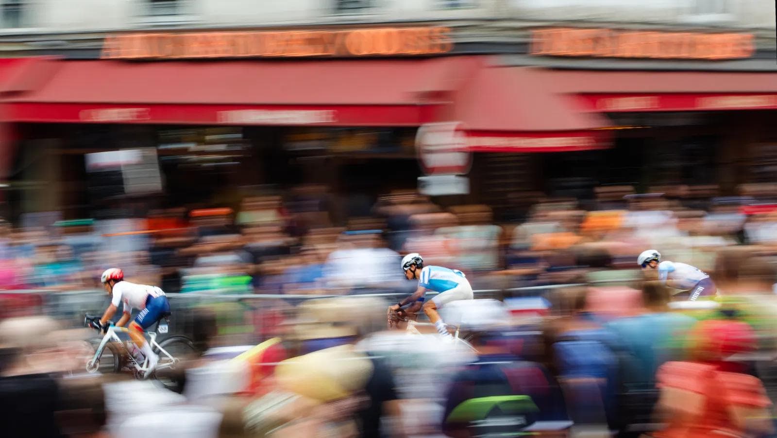 Cyclistes en panning devant une devanture parisienne