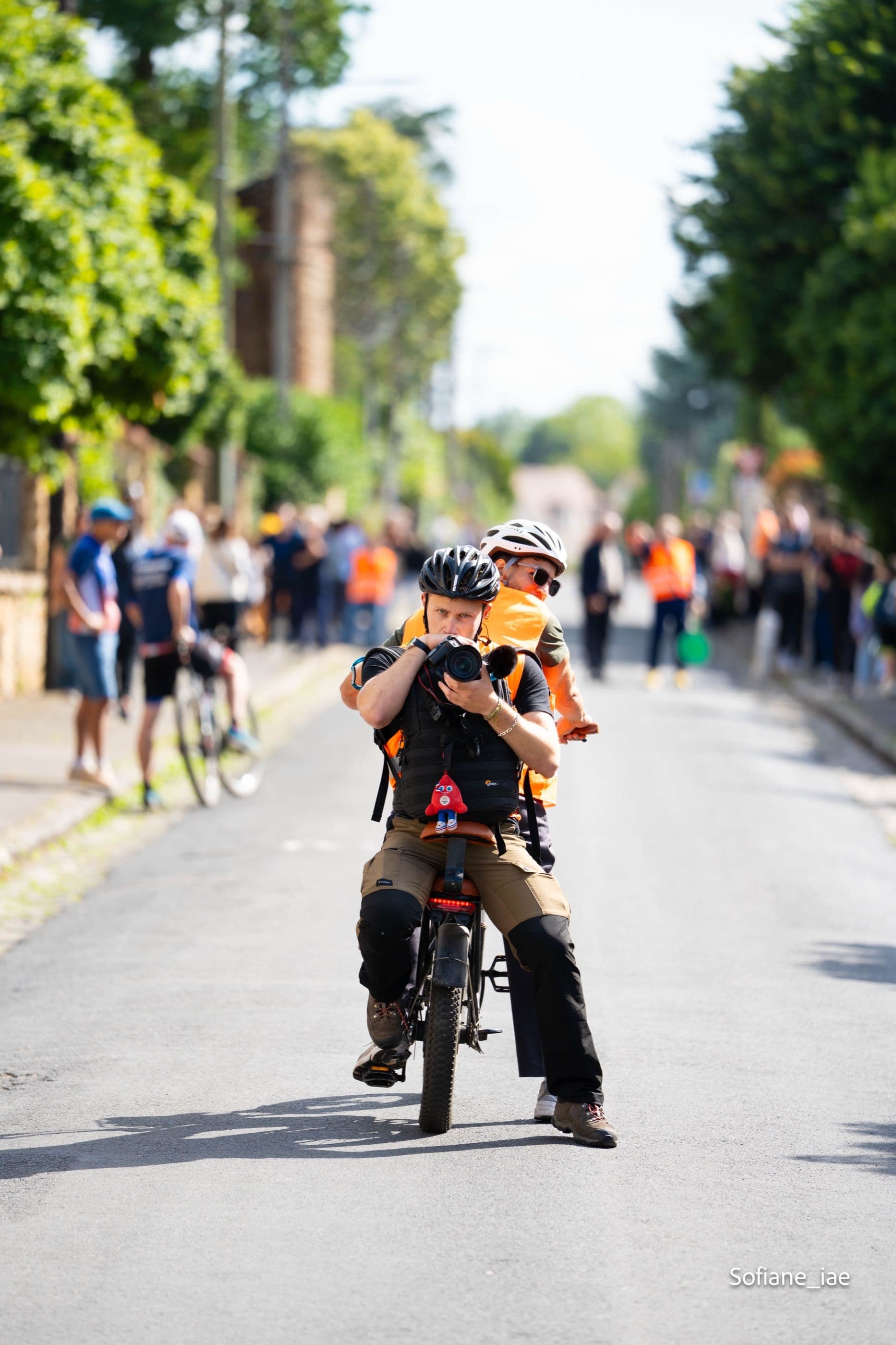 Théo Dehenz photographiant une course depuis son vélo